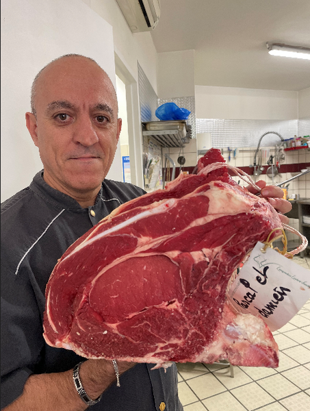 Pascal Ortega présentant une côte de bœuf dans son atelier